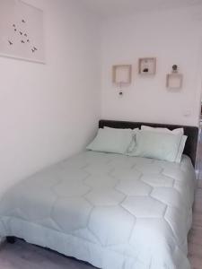 uma cama branca num quarto branco com uma parede branca em Casa do Frade em Cabeço de Alhos Vedros