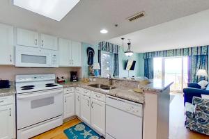 una cocina con armarios blancos y un horno de fogón blanco en Bay Watch 0232, en Myrtle Beach