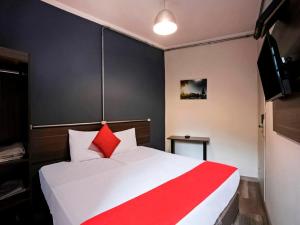 a bedroom with a red and white bed and a television at MOVA 104 - Hotel Consulado Avenida Paulista in Sao Paulo