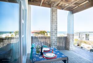 a table on a balcony with a view of the ocean at Kaalvoet Self-Catering Apartments in Yzerfontein