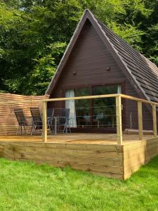 a large wooden deck with chairs and a house at Hayfield lodge in Spean Bridge