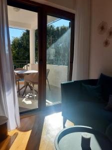 uma sala de estar com um sofá e uma porta de vidro deslizante em Green Bay em Baošići