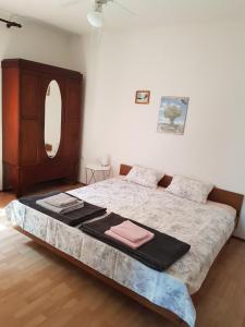 een slaapkamer met een bed, een dressoir en een spiegel bij Apartment Ute in Mali Lošinj