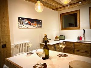 梅傑夫的住宿－A place 2 be, Megève centre，厨房配有一张桌子,上面放有两杯葡萄酒