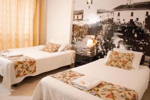 a hotel room with two beds and a mirror at HOTEL TORRE REAL in Popayan