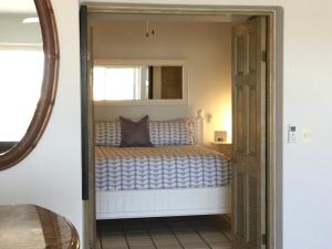 a small bedroom with a bed with a mirror at Ocean View Cabo Condo Create Memories!! in San José del Cabo