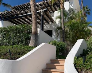 圣何塞德尔卡沃Ocean View Cabo Condo Create Memories!!的白色的房子,有楼梯和棕榈树