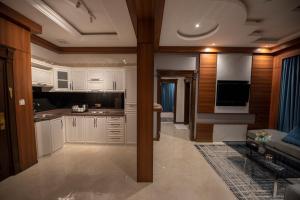 a kitchen with white cabinets and a living room at Elite Najran in Najran