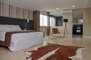 a bedroom with a large bed with a rug on the floor at M Tower Hotel in Pelotas