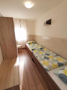 a room with two beds and a window at Gyöngyvirág Apartmanház in Hajdúszoboszló