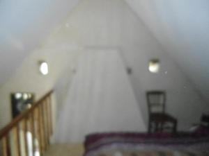Zimmer im Dachgeschoss mit einer Treppe und einem Stuhl in der Unterkunft LA VUULE MAISON in Fermanville