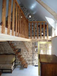 una escalera de madera en una habitación con una pared de ladrillo en LA VUULE MAISON en Fermanville