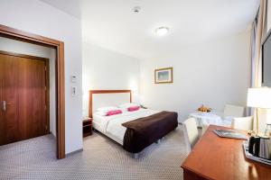 a hotel room with a bed and a desk and a desk at Hotel Federale in Lugano