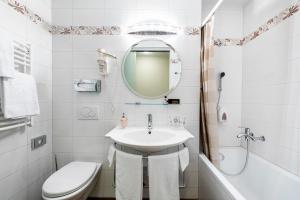 ein Badezimmer mit Waschbecken, Toilette und Spiegel in der Unterkunft Hotel Federale in Lugano + 32 Fotos
