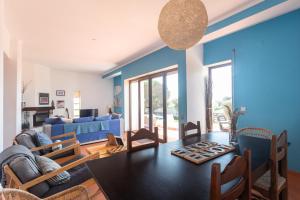 sala de estar con mesa y pared azul en Blue Buddha Beach House, en Ericeira