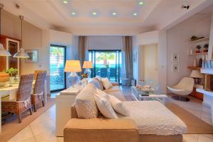 a living room with a couch and a dining room at Villa Sofias in Pefkochori