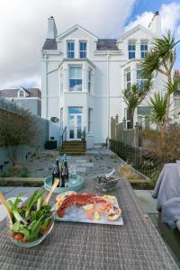 a table with a plate of food and a house at Craig Hyfryd in Beaumaris