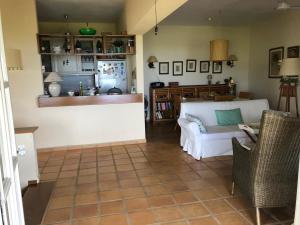 a living room with a white couch and a kitchen at Villa Bouboule in Vromolimnos