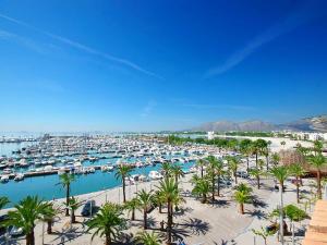 un puerto deportivo con muchos barcos y palmeras en Apartment Xara Torres, at the Beach of Alcudia en Puerto de Alcúdia