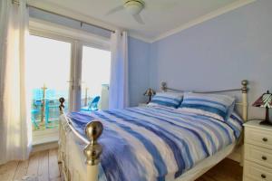 Schlafzimmer mit einem Bett und Meerblick in der Unterkunft Serenity "your calm seafront retreat" By Air Premier in Seaford