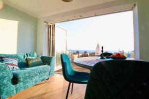 ein Wohnzimmer mit einem blauen Sofa und einem Tisch in der Unterkunft Serenity "your calm seafront retreat" By Air Premier in Seaford