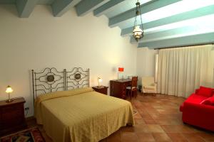 a bedroom with a bed and a red couch at Torre Archirafi Resort in Riposto