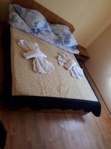 a bed with two white towels on it at Casa Ionel si Dani in Fundata