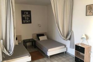 1 dormitorio pequeño con 1 cama y TV en studio meublé classé 2 étoiles - 30m² en Gréoux-les-Bains