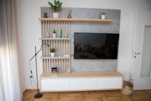 uma sala de estar com uma televisão e um armário branco em Apartment Dream Trebinje em Trebinje