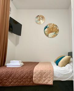 ein Schlafzimmer mit einem Bett und zwei Platten an der Wand in der Unterkunft MYFREEDOM Апартаменти метро Лук'янівська in Kiew
