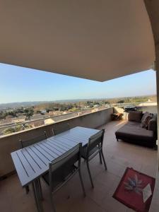 ein Wohnzimmer mit einem Tisch und einem Sofa in der Unterkunft Terrasse sur les Alpilles in Saint-Rémy-de-Provence