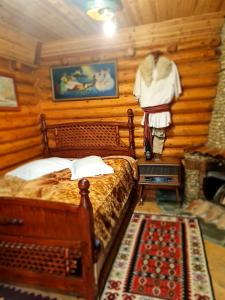 a bedroom with a bed and a wooden wall at Sofra Kolonjare Agroturizem in Ersekë