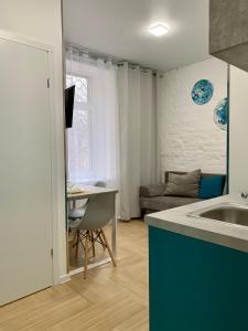 a kitchen with a sink and a table and a couch at Апартаменти MYFREEDOM поруч із метро Лук'янівська in Kyiv