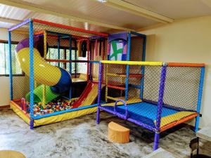 una sala de juegos para niños con un parque infantil con tobogán en Sanctuary Pirenópolis Suítes e Flats, en Pirenópolis