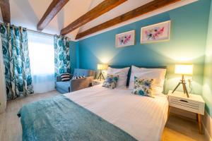ein Schlafzimmer mit einem großen Bett mit blauen Wänden in der Unterkunft Lawendowe wzgórze Apartamenty in Mikołajki