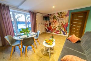 a living room with a couch and a table with a bowl of fruit at Lawendowe wzgórze Apartamenty in Mikołajki