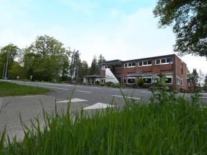 a building on the side of a road with grass at Hotel de Grote Zwaan in De Lutte