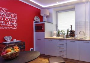 a kitchen with red walls and a bowl of fruit on a table at Ferienwohnung Tiergarten in Berlin +23 photos