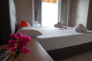 a bedroom with a bed with pink flowers on a table at Sea Sound in Vasiliki