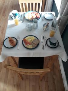 a white table with breakfast foods on it at Dubhlinn House in Doolin