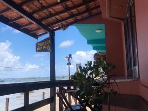 un restaurante con vistas a la playa desde el balcón en Pousada Mar Azul Morro, en Morro de São Paulo