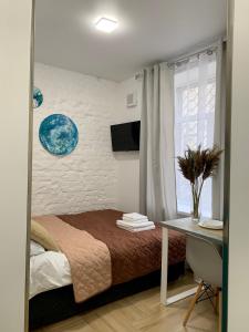 a bedroom with a bed and a desk and a window at MYFREEDOM Апартаменти метро Лук'янівська in Kyiv