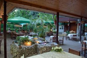 ein Restaurant mit einer Steinterrasse und einer Feuerstelle in der Unterkunft Hotel Les in Razgrad