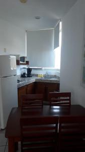 布塞里亞斯的住宿－Banderas Suites，厨房配有桌椅和白色冰箱。