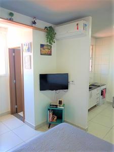 sala de estar con TV de pantalla plana en la pared en Meu Apê Maringá - UEM - Perto de tudo!, en Maringá