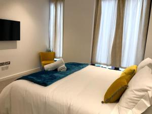 Dormitorio con cama con almohada amarilla en Maplewood luxurious one-bed flat with free parking, en Saint Albans