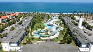uma vista aérea de um resort com piscina e oceano em Beach class Muro Alto Flat em Porto de Galinhas