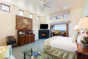 ein Schlafzimmer mit einem Bett und einem Kamin in der Unterkunft Tally Ho Inn in Carmel