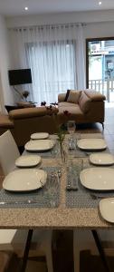 mesa de comedor con platos y vasos y sofá en Panthoma Casa, en Ayia Napa