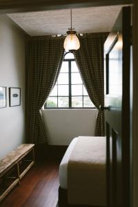 a bedroom with a bed and a window at The Convent Hotel in Auckland